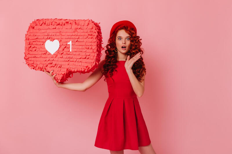 shocked girl looks camera holding like sign pink background portrait woman red dress beret